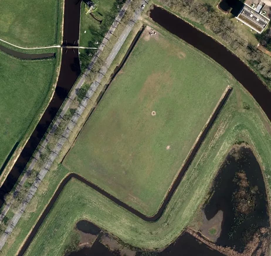 Luchtfoto van een grasperceel tussen sloten