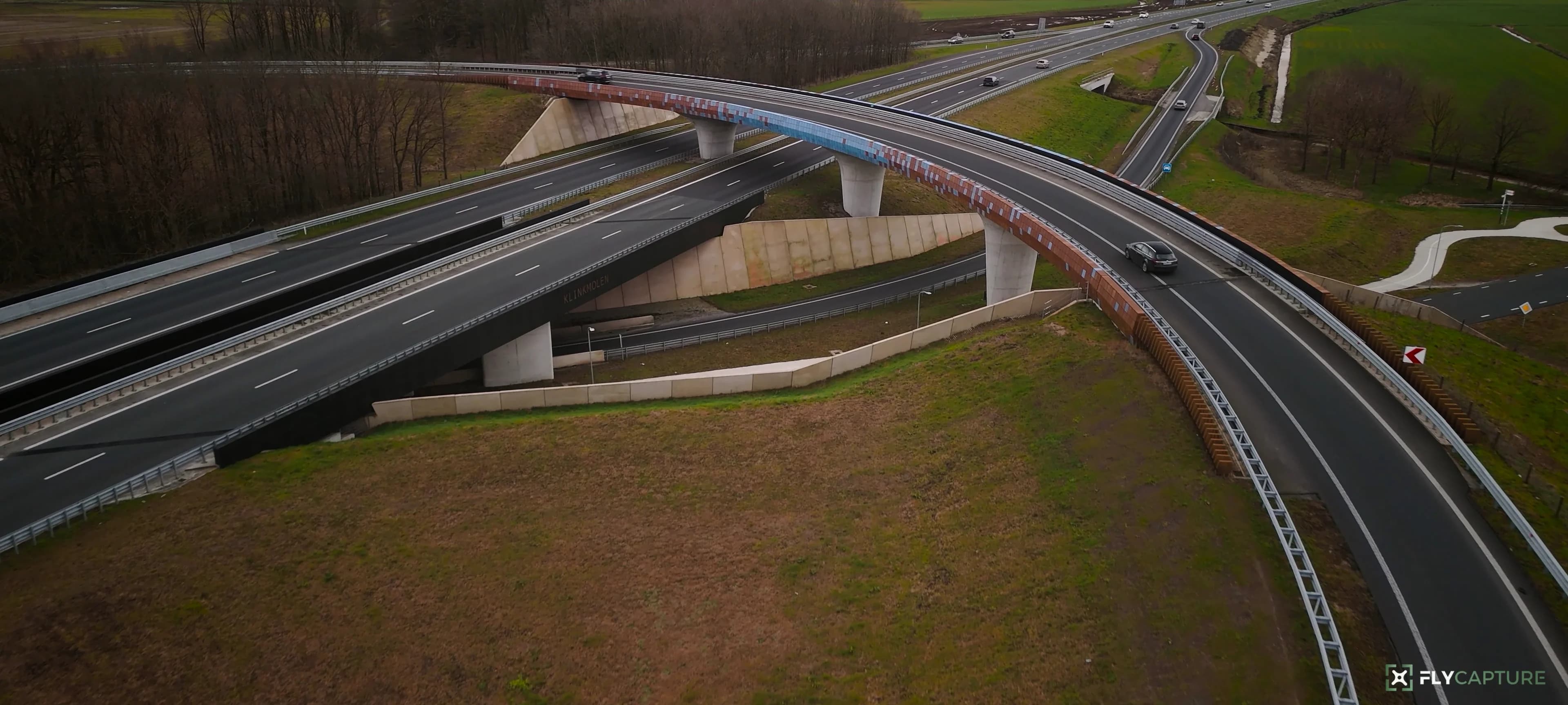 Snelwegknooppunt met een gebogen toerit vanuit de lucht